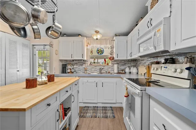 a view of a livingroom with furniture hardwood floor a ceiling fan and windows