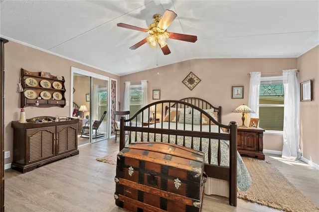 a bedroom with a bed a dresser and a chandelier