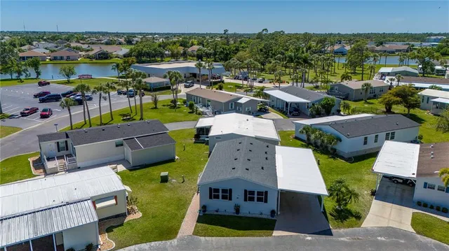 an aerial view of residential houses with outdoor space and lake view