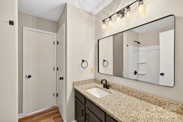 a bathroom with a granite countertop sink and a mirror
