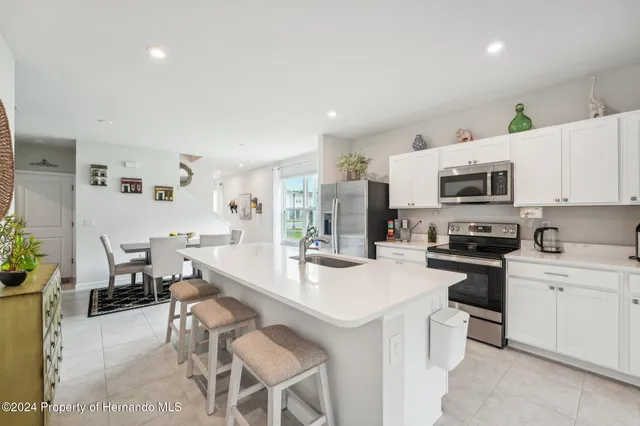 a kitchen with a sink stainless steel appliances and white cabinets