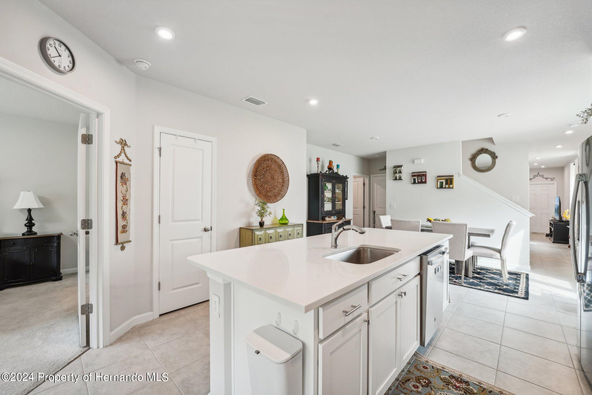 12214 Grizzly Lane New Port Richey, FL 34654 - Photo 19 of 49 a kitchen with a sink a stove and chairs with wooden floor