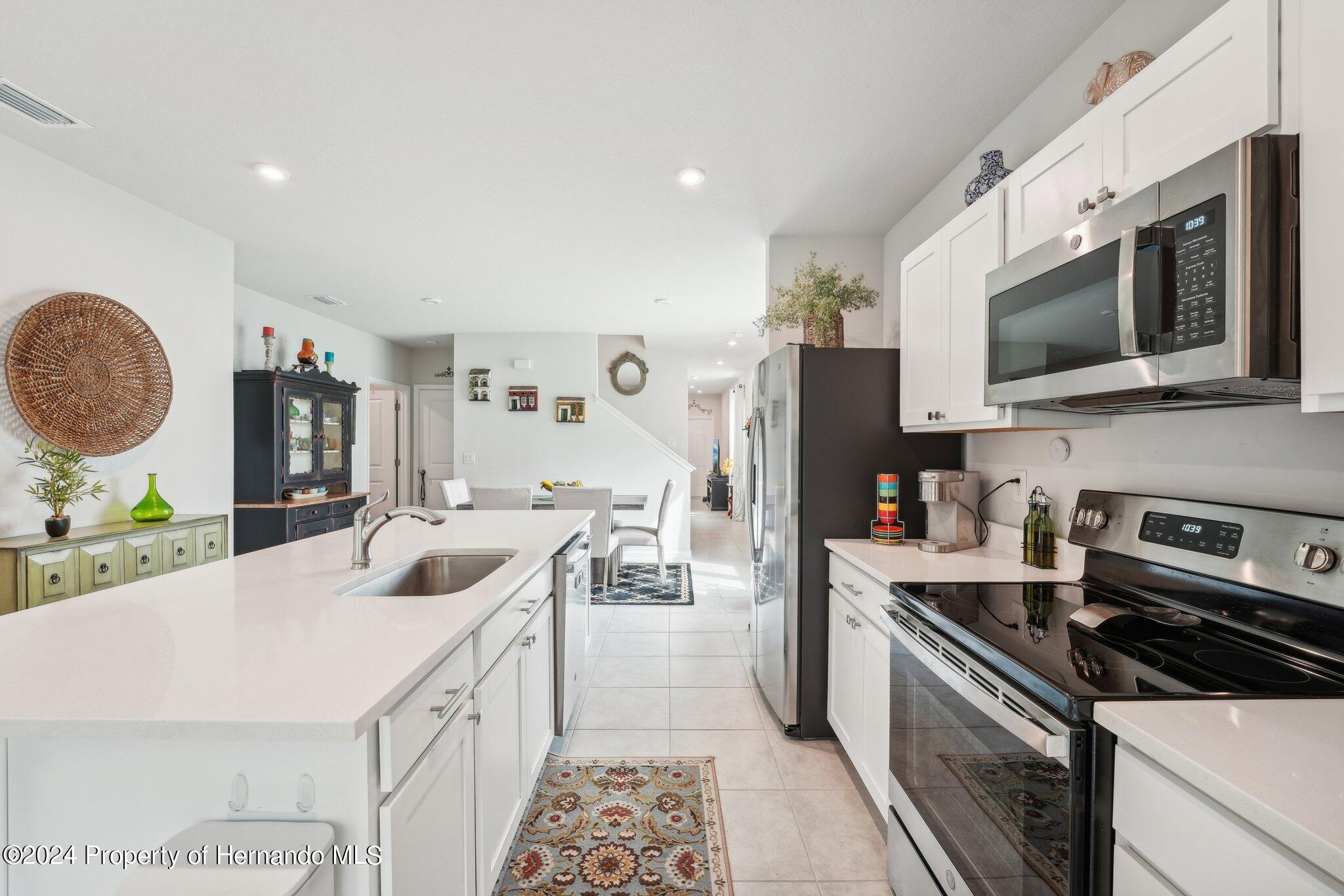 12214 Grizzly Lane New Port Richey, FL 34654 - Photo 20 of 49 a kitchen with stainless steel appliances a sink stove top oven and microwave