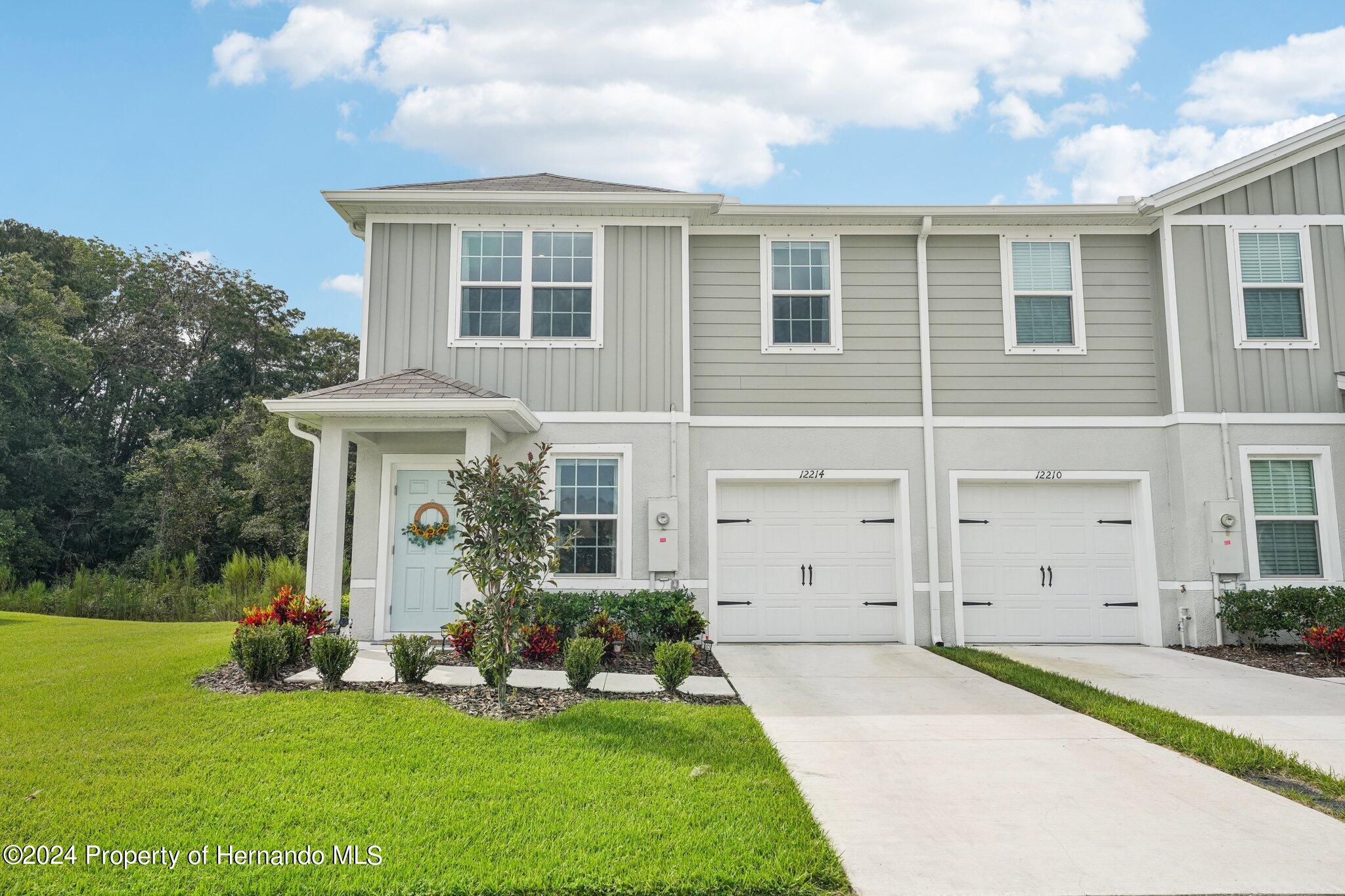 12214 Grizzly Lane New Port Richey, FL 34654 - Photo 2 of 49 a front view of a house with a yard and trees
