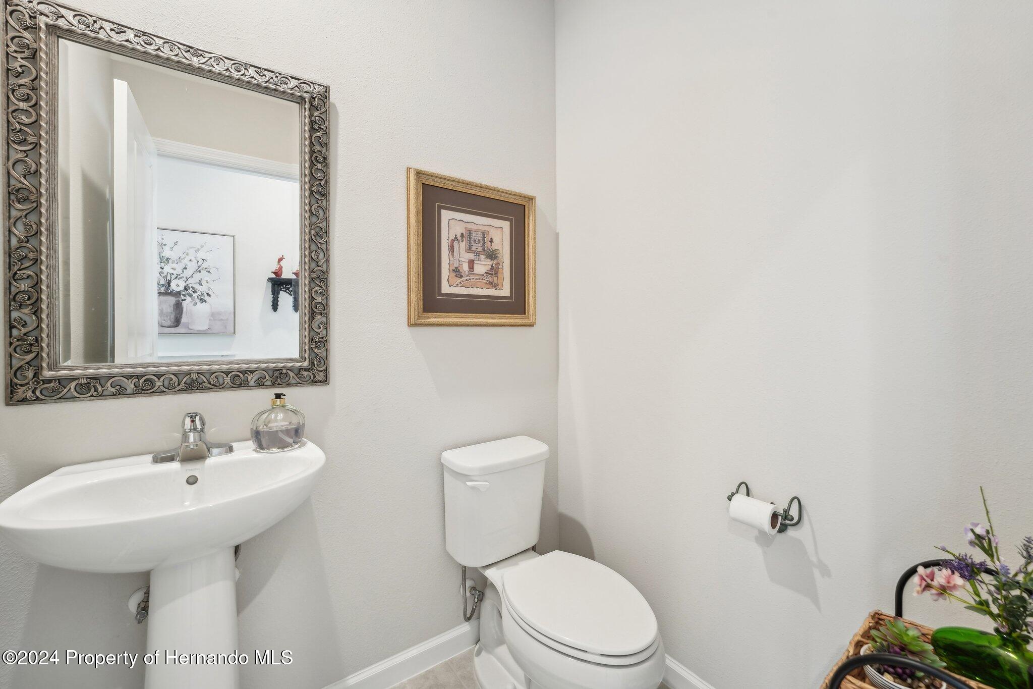 12214 Grizzly Lane New Port Richey, FL 34654 - Photo 21 of 49 a bathroom with a toilet sink and mirror
