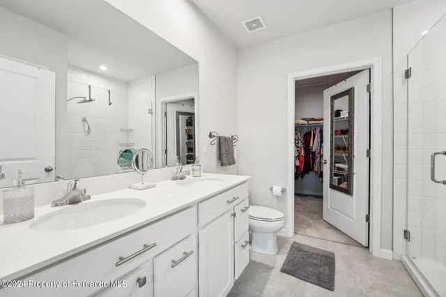 a spacious bathroom with a double vanity sink toilet and shower