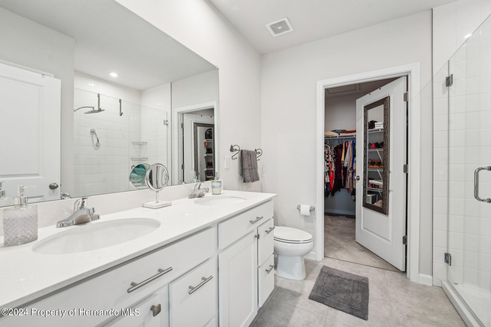 12214 Grizzly Lane New Port Richey, FL 34654 - Photo 29 of 49 a spacious bathroom with a double vanity sink toilet and shower
