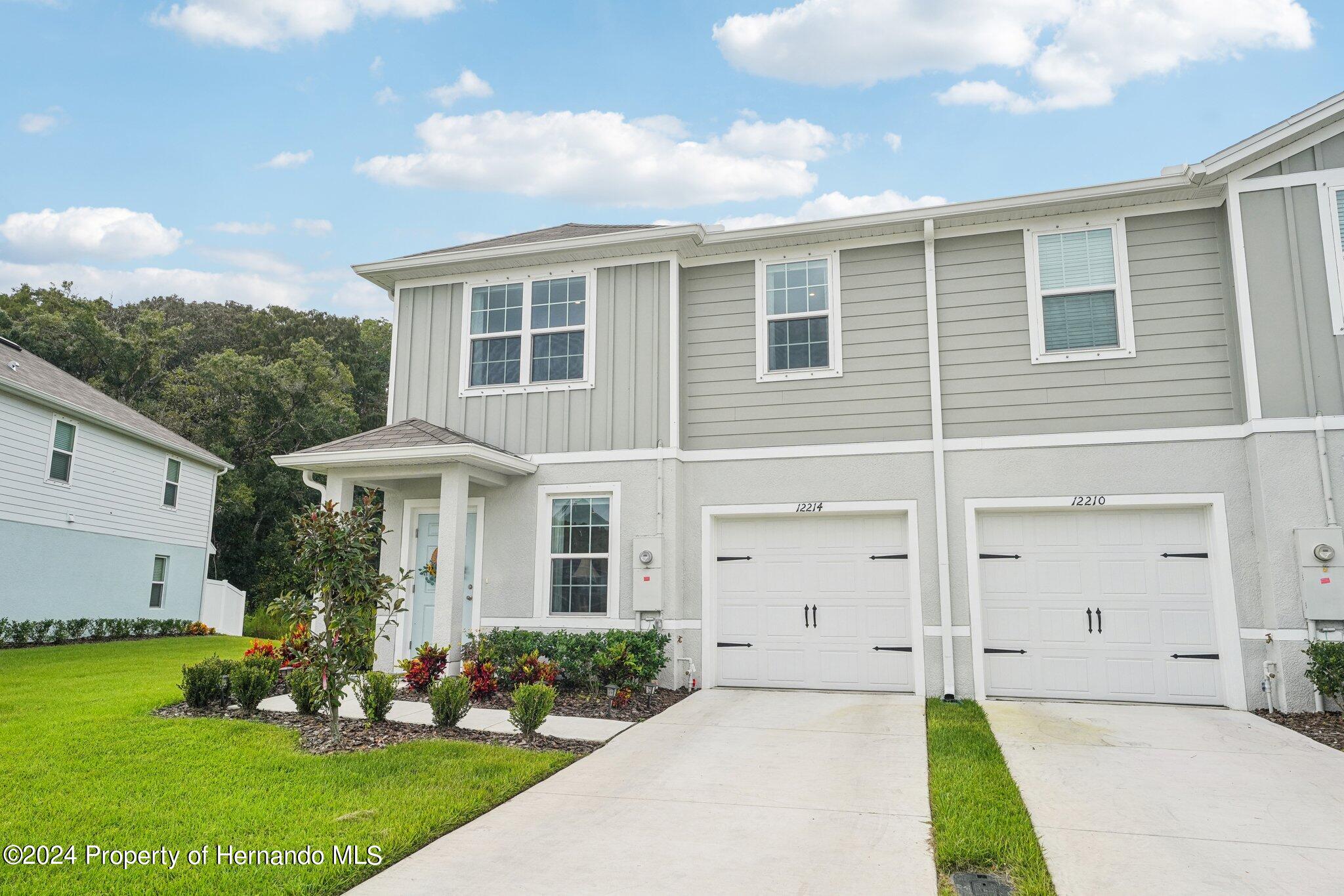 12214 Grizzly Lane New Port Richey, FL 34654 - Photo 3 of 49 a front view of a house with a garden and plants
