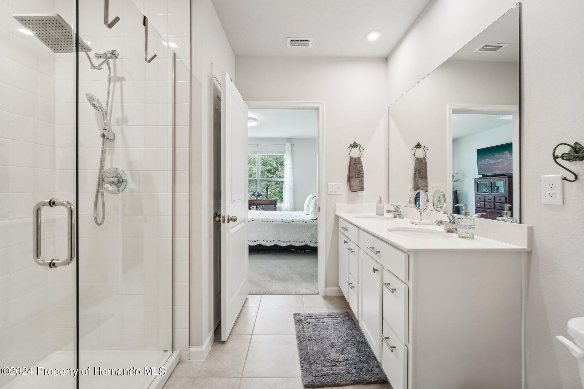 12214 Grizzly Lane New Port Richey, FL 34654 - Photo 34 of 49 a bathroom with a double vanity sink mirror and shower