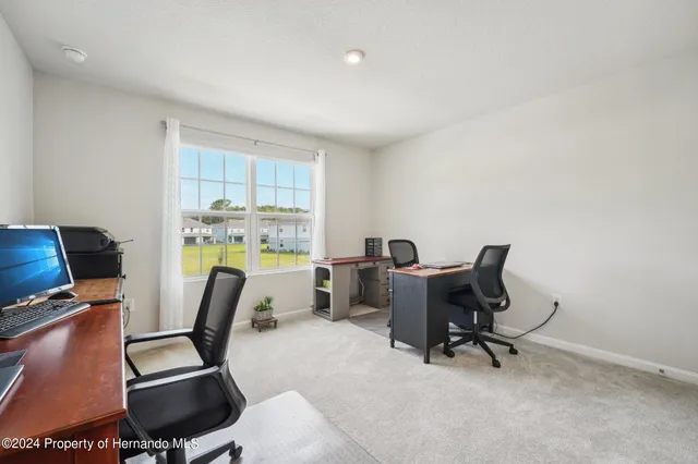 a view of a workspace with furniture and a window