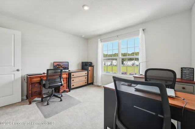 a view of a workspace with furniture and a window