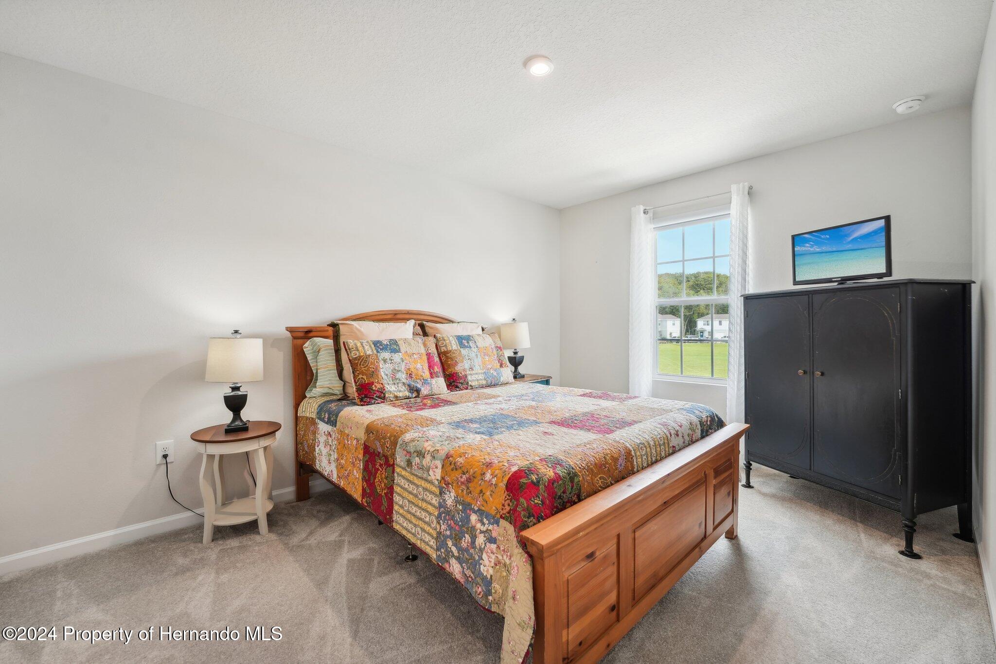12214 Grizzly Lane New Port Richey, FL 34654 - Photo 39 of 49 a bedroom with a bed and a refrigerator