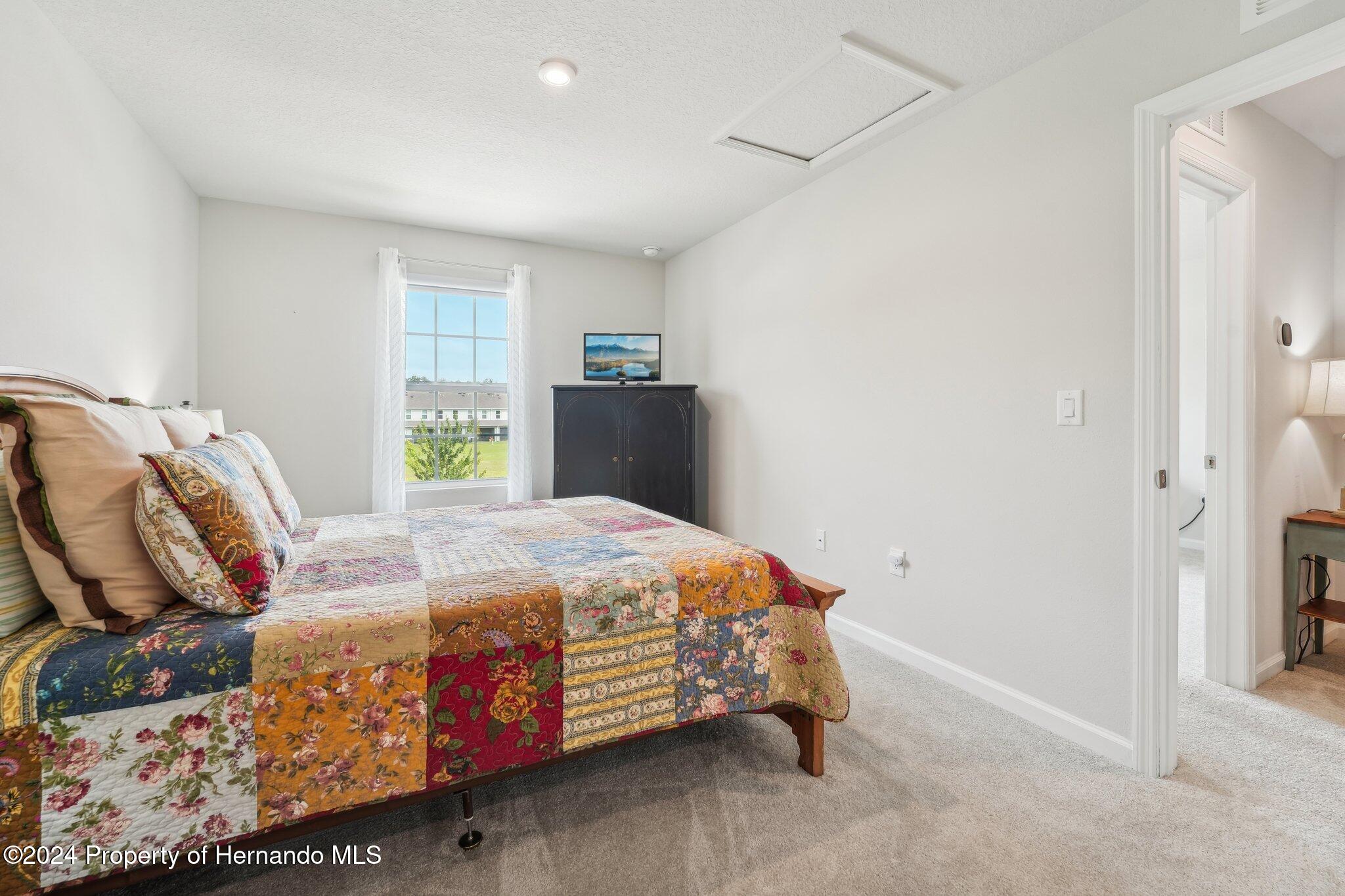 12214 Grizzly Lane New Port Richey, FL 34654 - Photo 40 of 49 a bedroom with a bed and a window