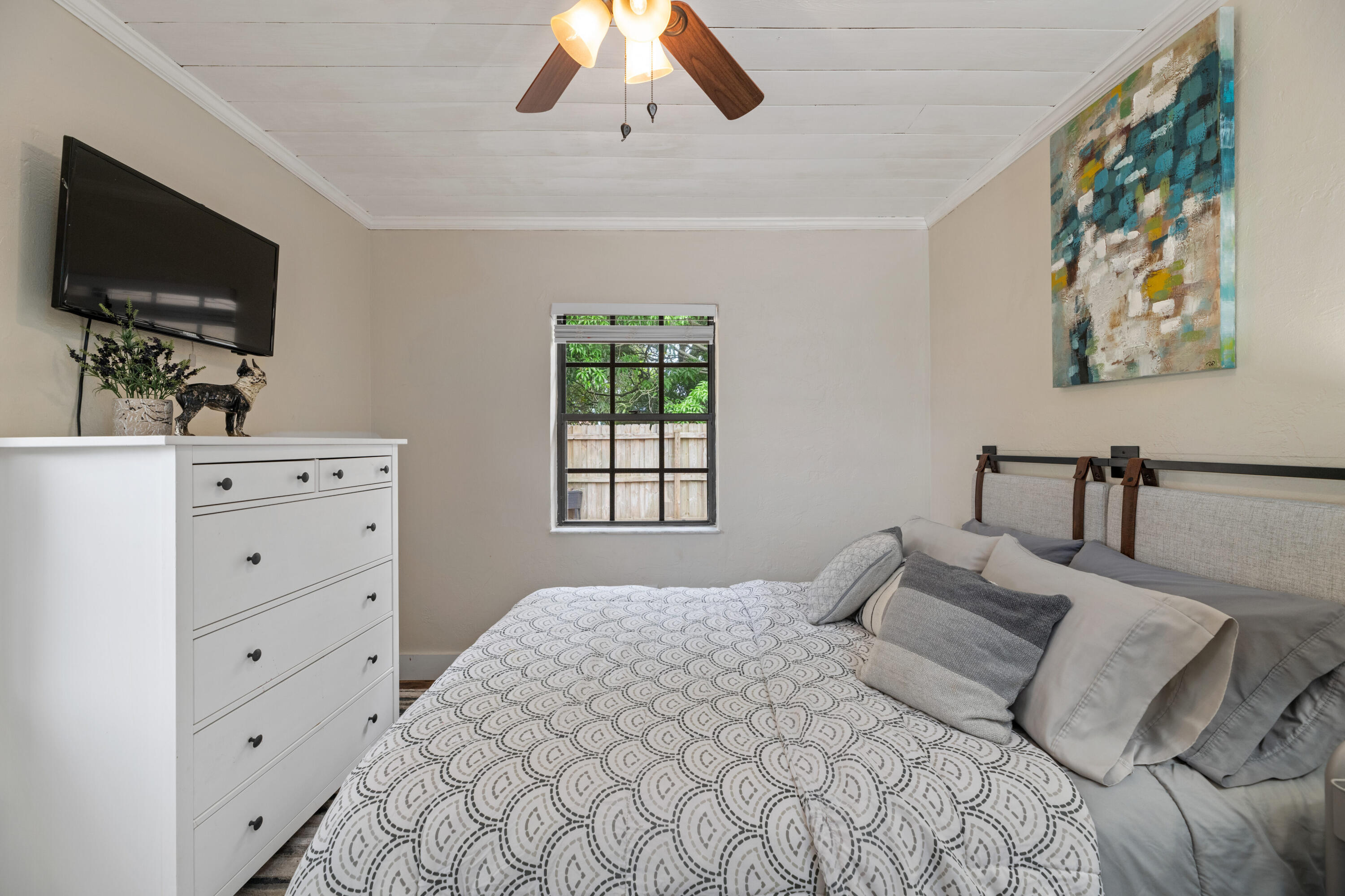 4534 County Line Road Tequesta, FL 33469 - Photo 15 of 26 a bedroom with a large bed and a flat tv screen on dresser