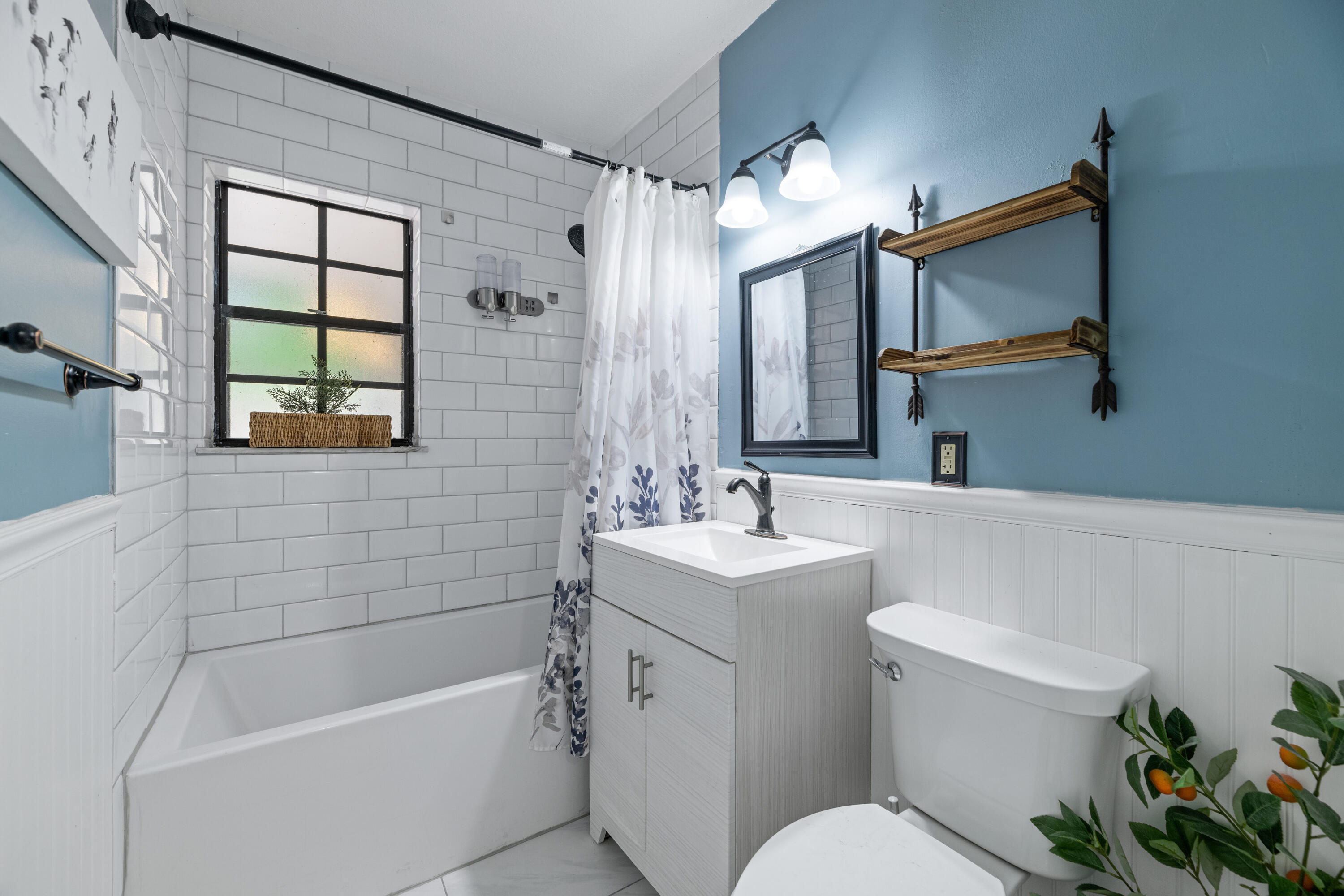 4534 County Line Road Tequesta, FL 33469 - Photo 17 of 26 a bathroom with a sink a toilet a mirror a bathtub and shower