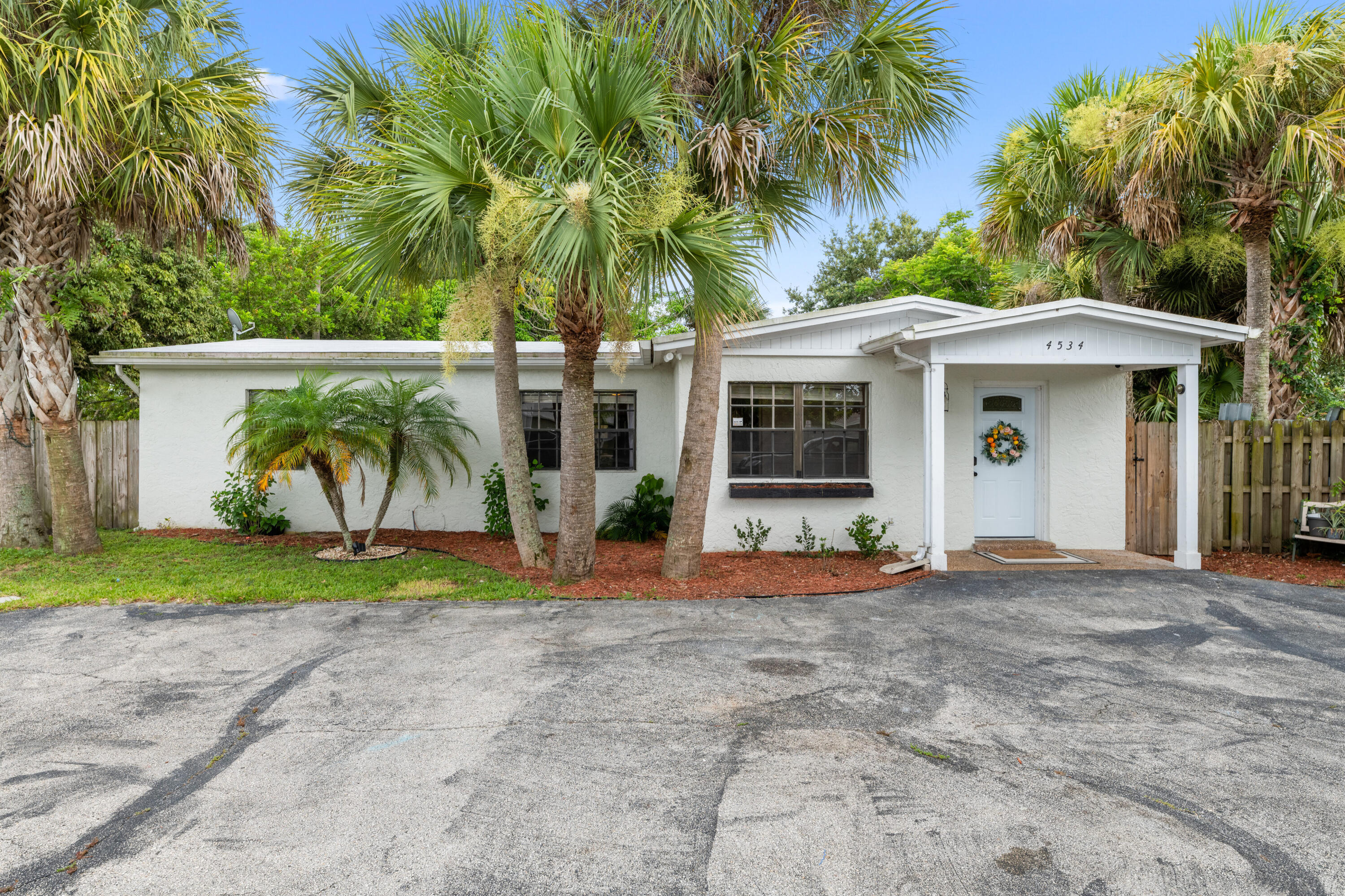 4534 County Line Road Tequesta, FL 33469 - Photo 2 of 26 a view of a house with a yard and palm trees