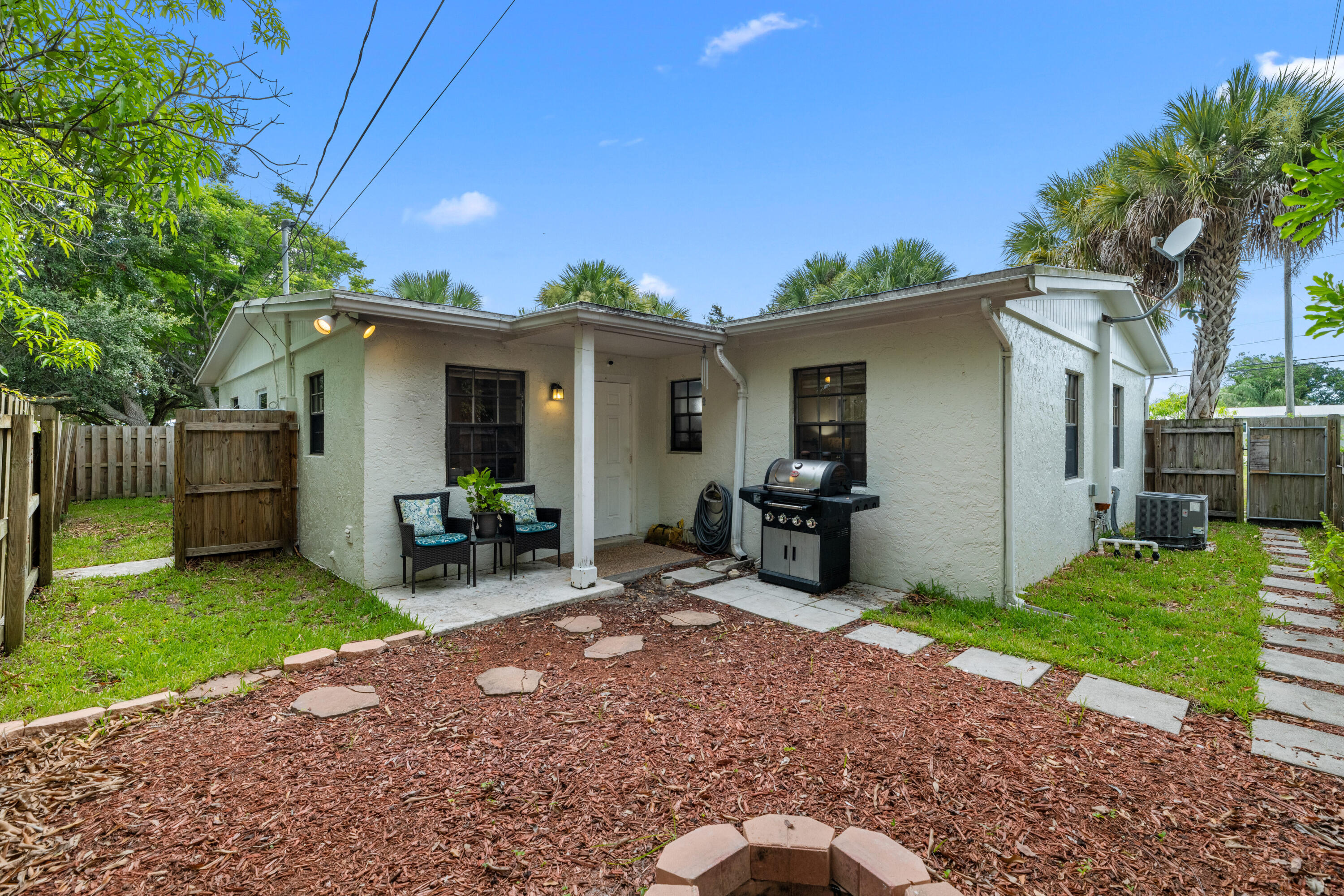 4534 County Line Road Tequesta, FL 33469 - Photo 22 of 26 a view of a chair and table in backyard of the house