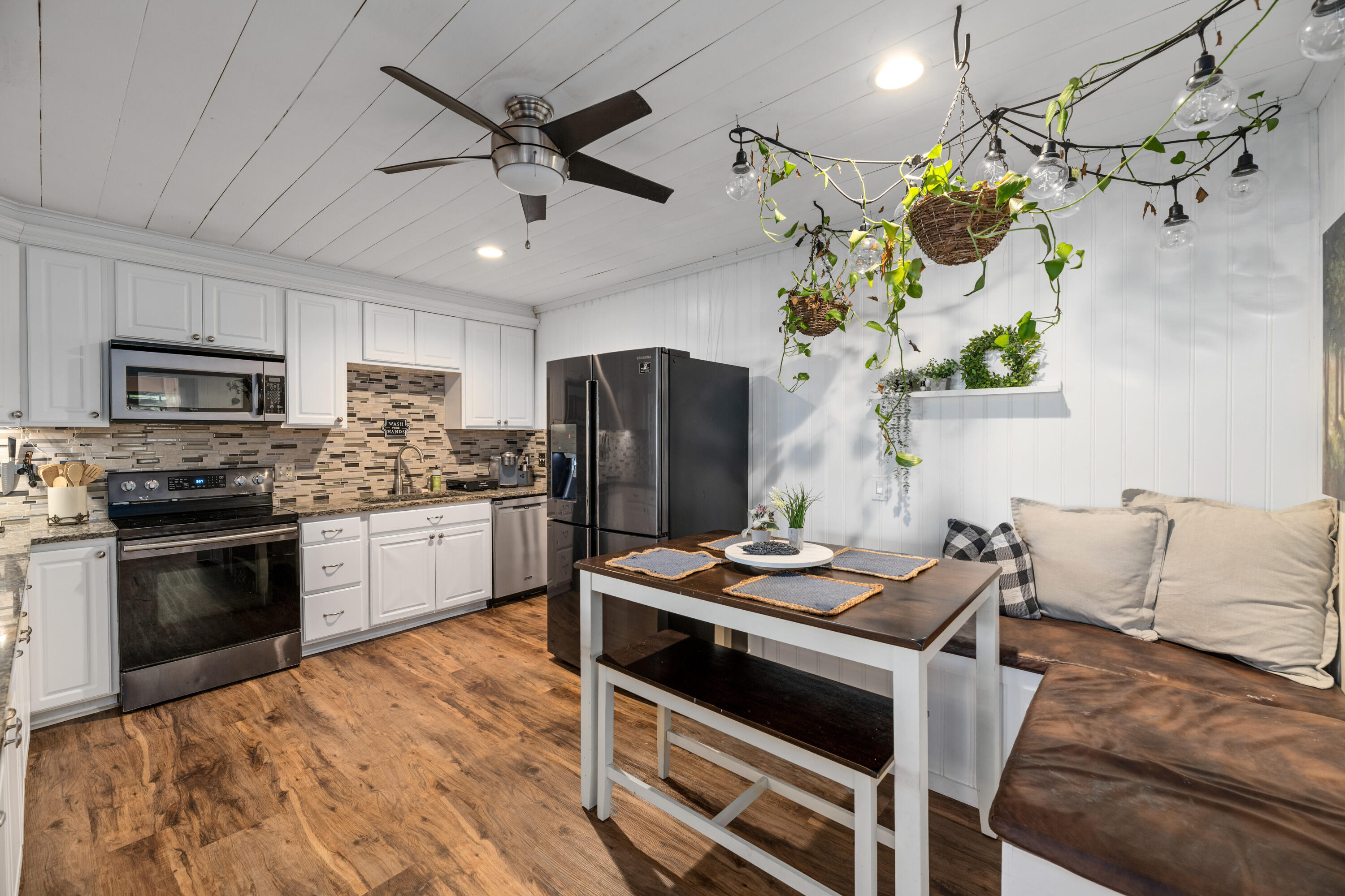 4534 County Line Road Tequesta, FL 33469 - Photo 5 of 26 a kitchen with stainless steel appliances kitchen island granite countertop a refrigerator a stove a microwave oven with a dining table and chairs
