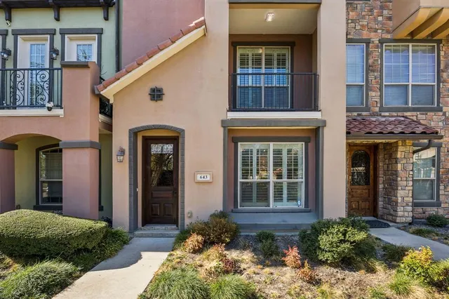 a view of a brick house with potted plants