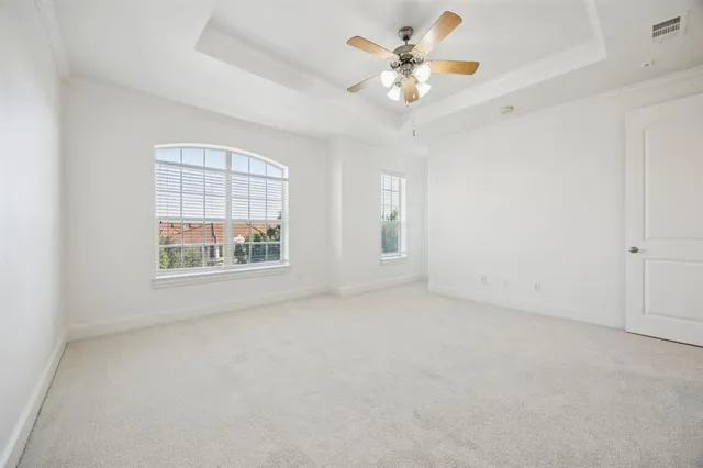 an empty room with windows and fan