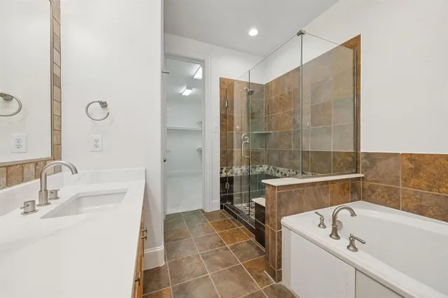 a bathroom with a tub a sink and a mirror