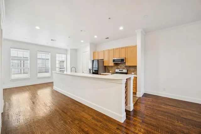 a view of kitchen with stainless steel appliances granite countertop a stove top oven a sink and a granite counter tops with wooden floors