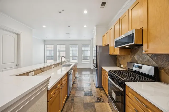 a kitchen with stainless steel appliances granite countertop a sink and a stove