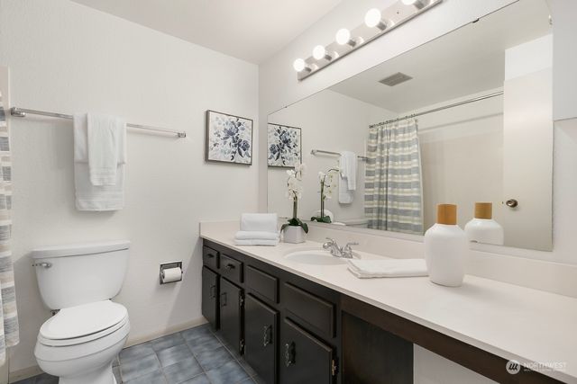 a bathroom with a sink a toilet and a large mirror