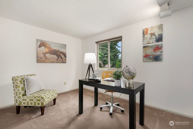 a view of a workspace with furniture and a window