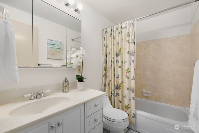 a bathroom with a sink a toilet and a large mirror