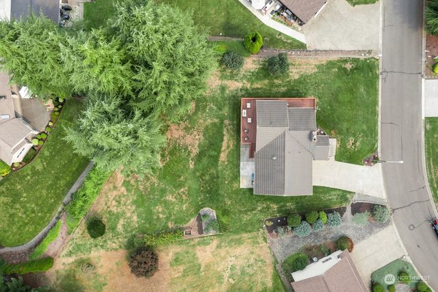 an aerial view of a house with a yard and large trees