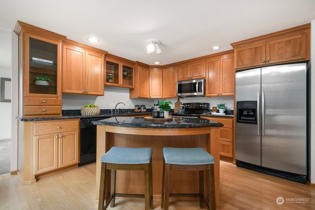 a kitchen with granite countertop stainless steel appliances and wooden cabinets