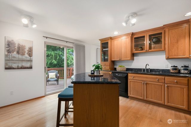 a kitchen with stainless steel appliances granite countertop sink stove and wooden cabinets