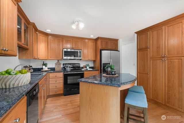 a kitchen with stainless steel appliances granite countertop a refrigerator stove microwave and sink