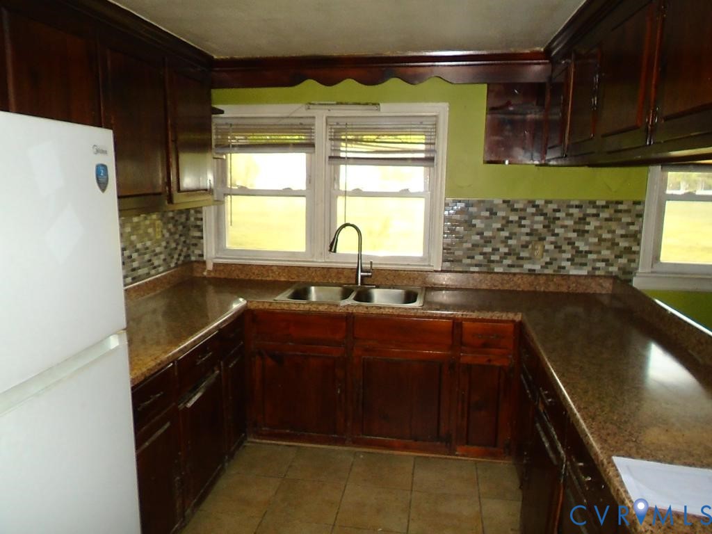 16203 West Patrick Henry Road Montpelier, VA 23192 - Photo 16 of 23 Kitchen with dark wood cabinetry and stone-look co