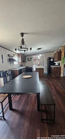 a living room with kitchen island stainless steel appliances and wooden floor