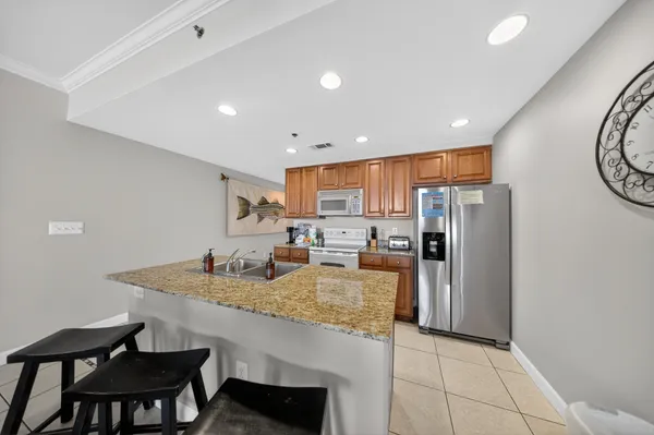 a kitchen with refrigerator and chairs