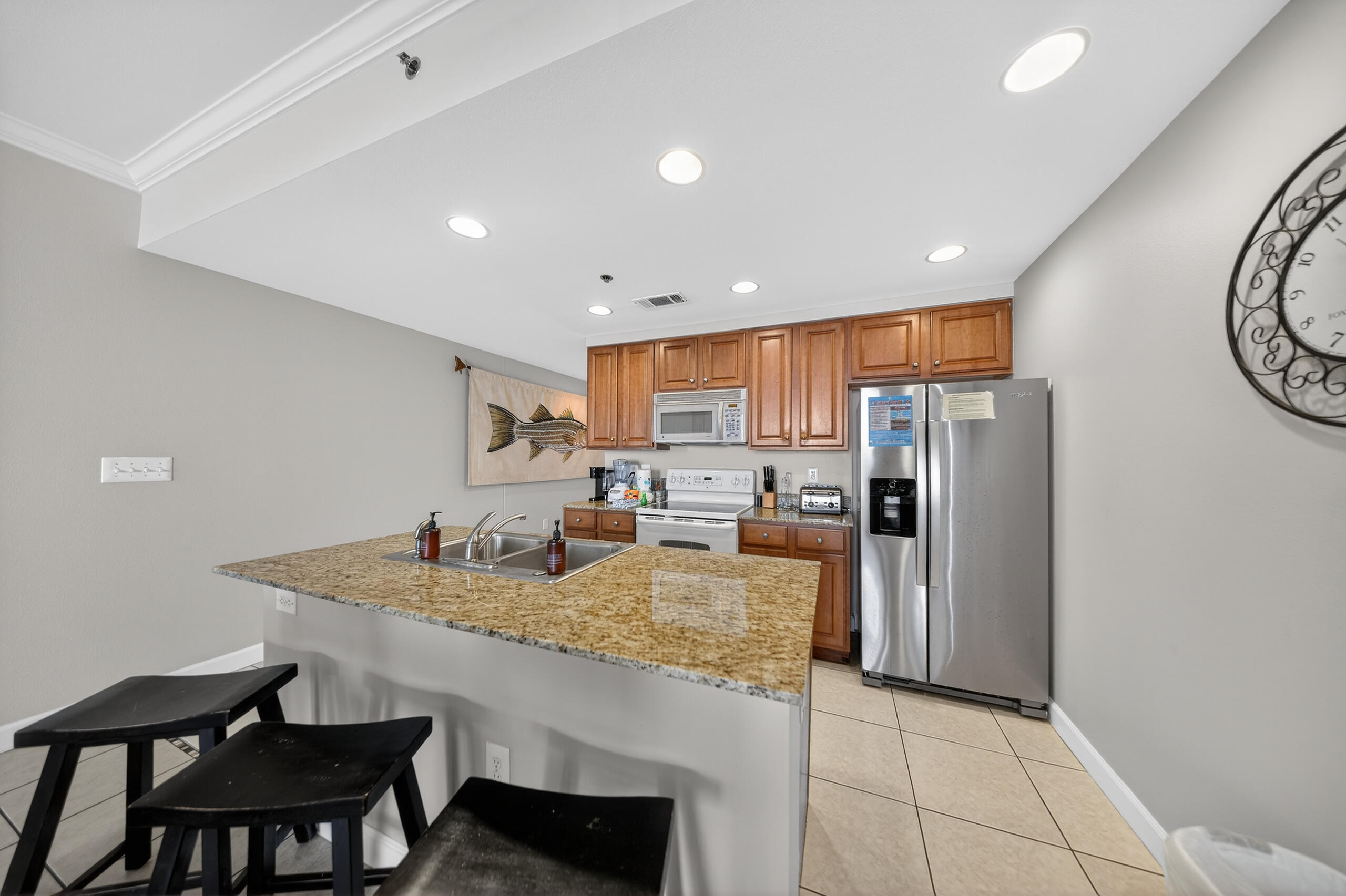 17739 Front Beach Road, Unit 1703W Panama City Beach, FL 32413 - Photo 15 of 50 a kitchen with refrigerator and chairs