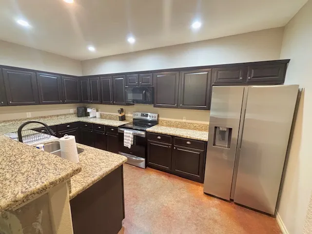 a kitchen with granite countertop stainless steel appliances and wooden cabinets