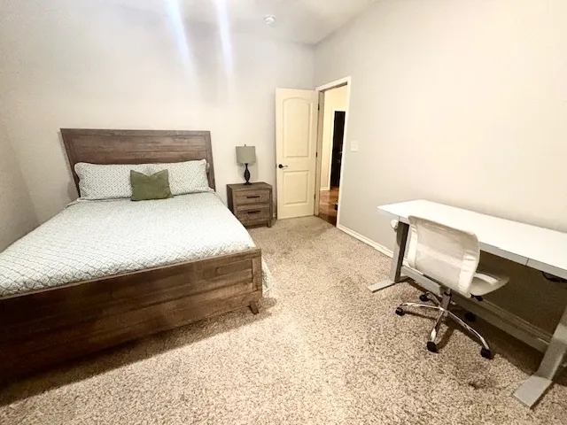 a bedroom with a bed a desk and chair