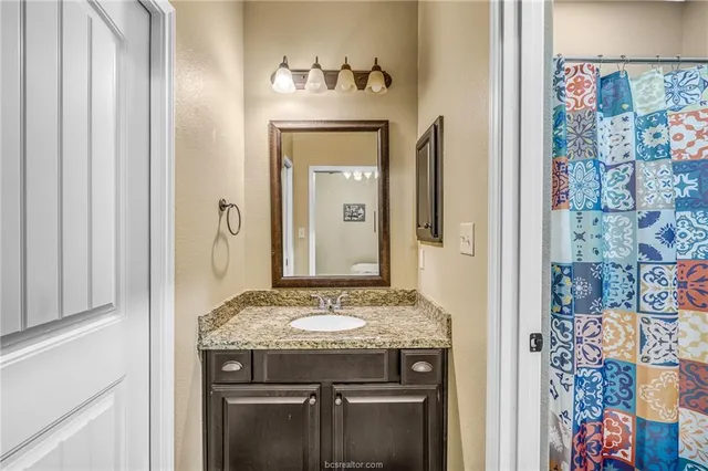a bathroom with a granite countertop sink and a mirror