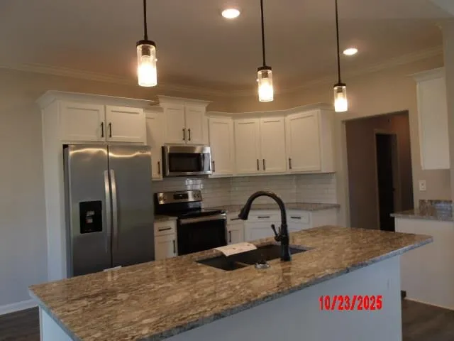 a kitchen with stainless steel appliances granite countertop a sink a refrigerator and a granite counter tops