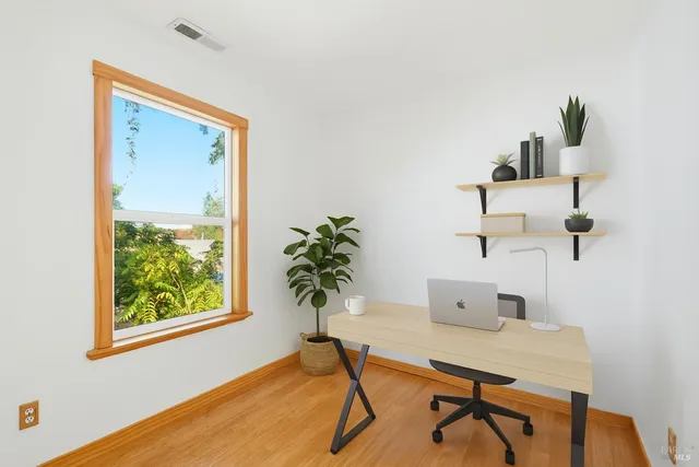 a workspace room with furniture and window