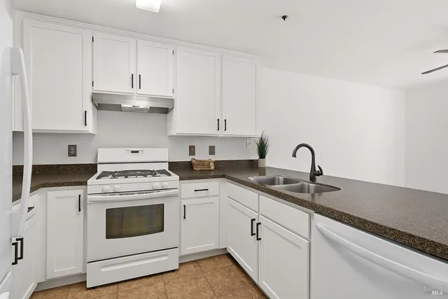 a kitchen with white cabinets sink and white appliances
