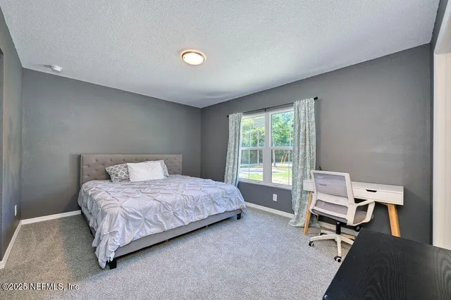 a bedroom with a bed a table and a window