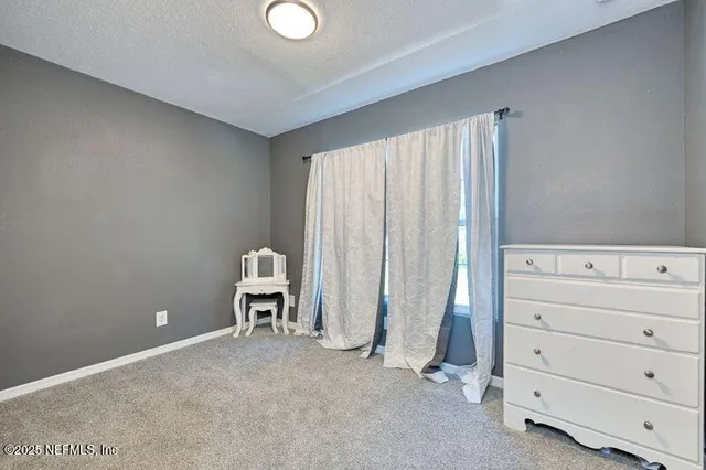 a room with a white bed and cabinet