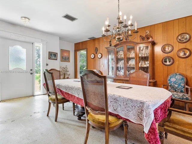 a view of a dining room with furniture and a chandelier