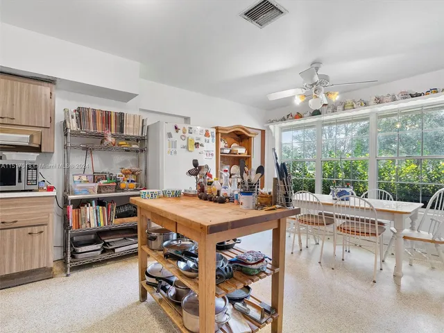a view of kitchen with stainless steel appliances kitchen island granite countertop a refrigerator and a stove
