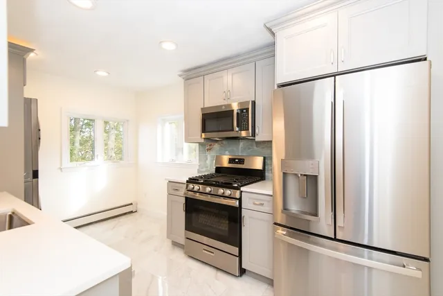 a kitchen with stainless steel appliances a refrigerator sink and microwave