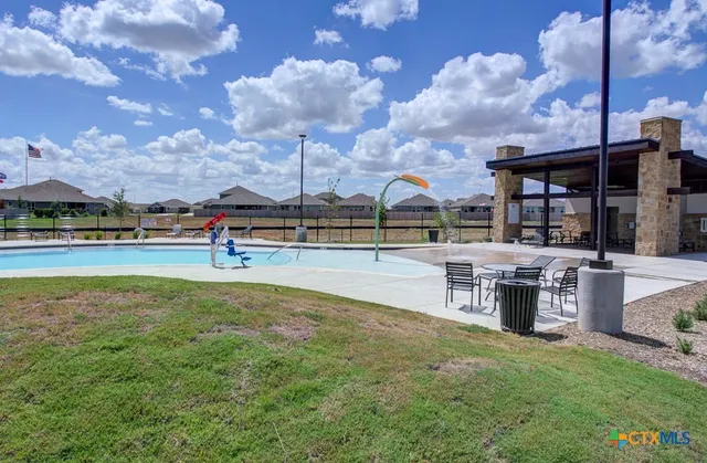 a swimming pool with outdoor seating and yard
